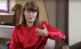 Alison Mackay sits while she gestures with her left hand and discusses her program J. S. Bach: The Circle of Creation for Tafelmusik Baroque Orchestra.