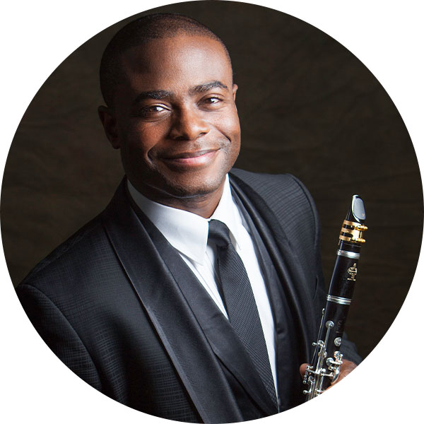 Anthony McGill smiles at the camera while holding his clarinet