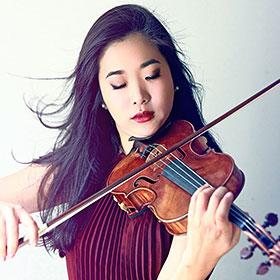 Kristin Lee plays the violin with her hair blowing in the wind.