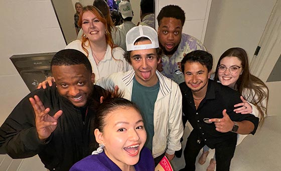 A group of students take a selfie with comedian Marcello Hernandez.