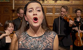 Soprano Forsythe passionately sings while the orchestra performs in the background.