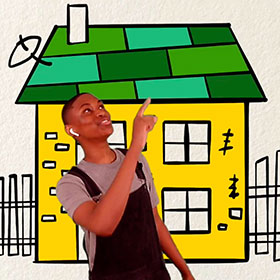 A boys stands in front of a drawing of a house.