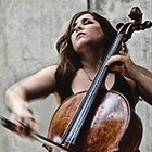 Classical musician Alisa Weilerstein, with her eyes closed and facing upward, performs a piece on her cello.