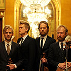 The members of the string quartet pose solemnly for a photo.