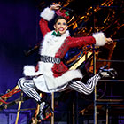 Angel leap across the stage wearing a Santa coat.