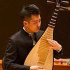 A man plays a traditional Chinese stringed instrument.