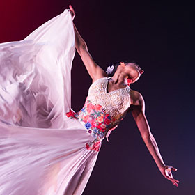 A dancer extends her arms as she spins around.
