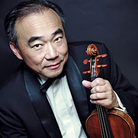 Lin wears a tux and holds his violin.