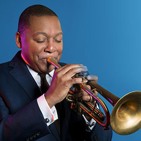 A man closes his eyes as he plays a trumpet.
